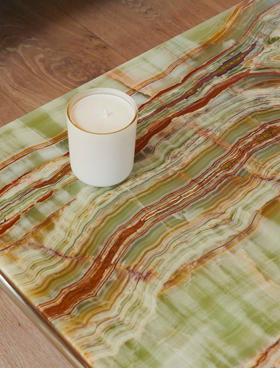 white candle on green wood grained table top